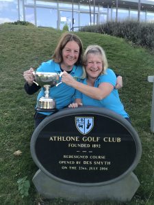 2 ladies wearing turquise, holding trophy beside Athlone Golf Club